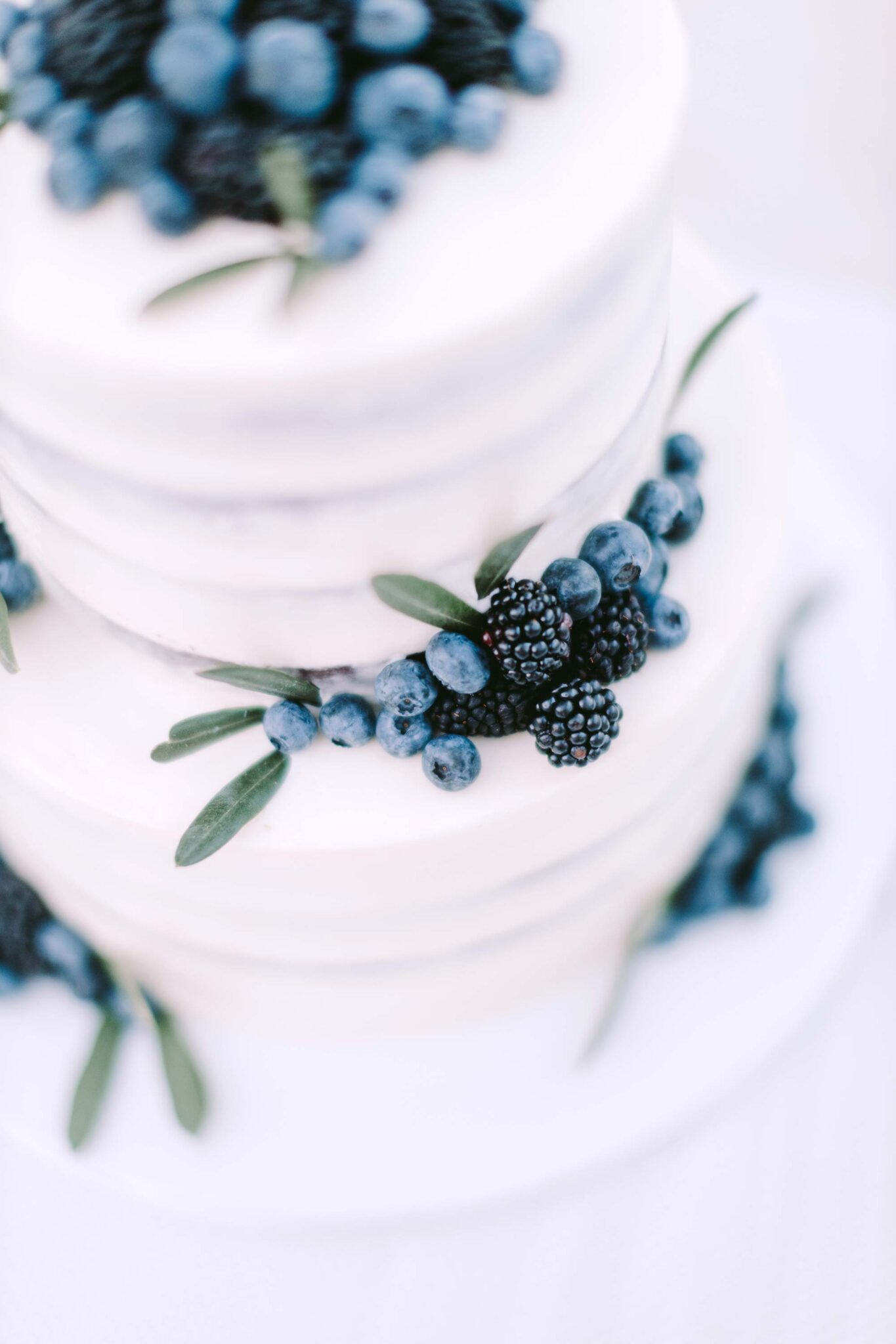 Weiße mehrstöckige Hochzeitstorte mit blauen Beeren vom Café Belstner in Landshut.